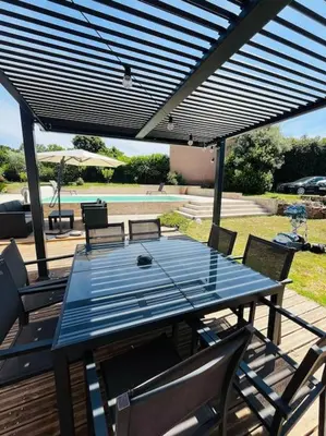 a blue table and chairs on a patio at Charmante Villa avec Piscine in Appietto