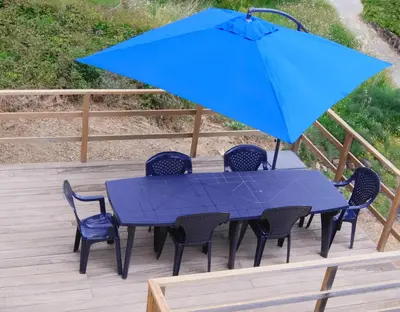 a blue table with chairs and an umbrella on a deck at Villa A Funtanella 100m2, paisible, vue mer in Conca