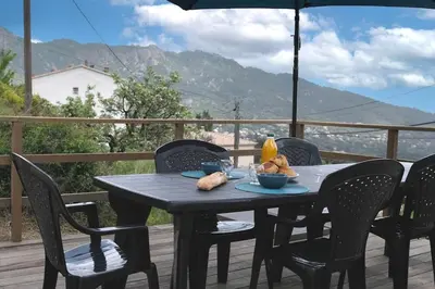 a black table with chairs and an umbrella on a deck at Villa A Funtanella 100m2, paisible, vue mer in Conca