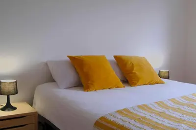 a bed with two yellow pillows on top of it at Villa A Funtanella 100m2, paisible, vue mer in Conca