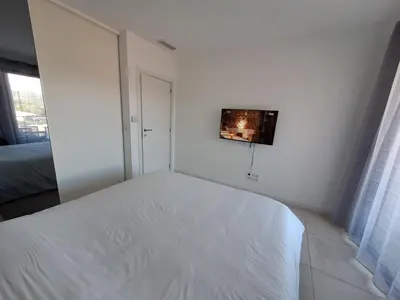 a white bedroom with a bed and a window at Magnifique T2 neuf à 100 m de la plage d'agosta in Albitreccia