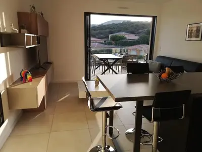 a kitchen and dining room with a table and a window at Magnifique T2 neuf à 100 m de la plage d'agosta in Albitreccia