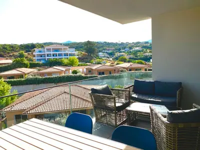 a balcony with a table and chairs and a view at Magnifique T2 neuf à 100 m de la plage d'agosta in Albitreccia