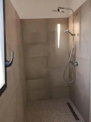 a shower with a shower head in a bathroom at Magnifique T2 neuf à 100 m de la plage d'agosta in Albitreccia