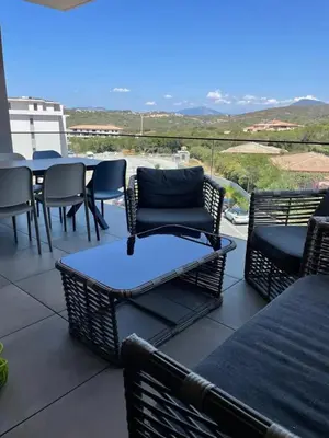 a patio with chairs and a table with a view at Magnifique T2 neuf à 100 m de la plage d'agosta in Albitreccia