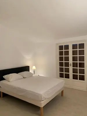 a white bed in a white room with a window at Maison DE VACANCES VUE MER PROCHE PLAGE AJACCIO SANGUINAIRES REF 1070 in Ajaccio
