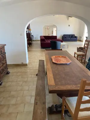 a living room with a table and a couch at Maison DE VACANCES VUE MER PROCHE PLAGE AJACCIO SANGUINAIRES REF 1070 in Ajaccio