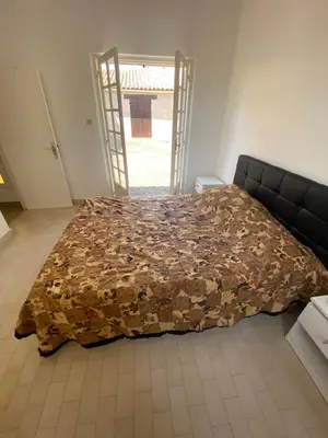 a bed in a room with a blanket on it at Maison DE VACANCES VUE MER PROCHE PLAGE AJACCIO SANGUINAIRES REF 1070 in Ajaccio