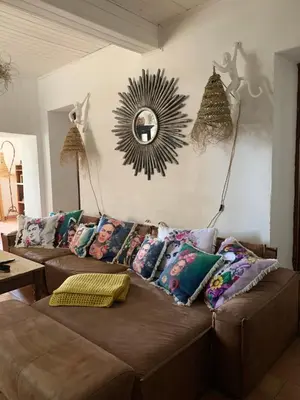 a living room with a brown couch with pillows at À casa nostra in Santo-Pietro-di-Tenda