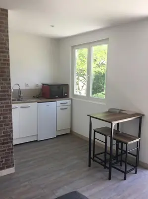 a kitchen with a table and a table and a window at chalet 19m2 pour 2 personnes in Omessa