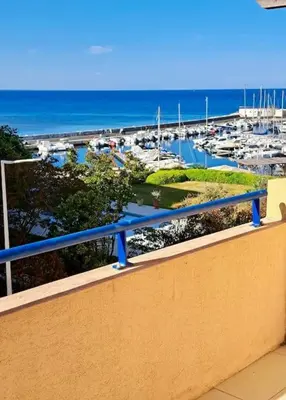a balcony with a view of a marina at Appartement Vue Mer in Sari Solenzara