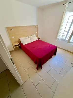 a bedroom with a bed with a red blanket at Appartement Vue Mer in Sari Solenzara