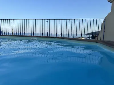 a swimming pool with a view of the ocean at Appartement Vue Mer in Sari Solenzara