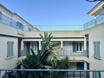 an apartment building with a palm tree in front of it at Appartement Vue Mer in Sari Solenzara