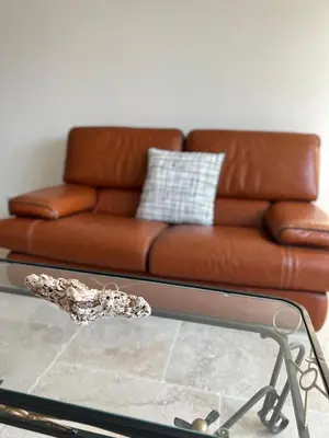 a brown leather couch sitting on top of a glass table at La maison du Soleil in Porticcio