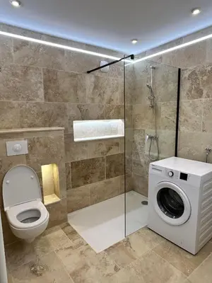 a bathroom with a toilet and a washing machine at La maison du Soleil in Porticcio