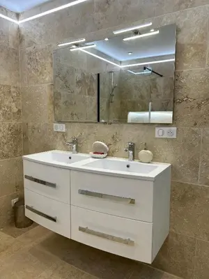 a bathroom with a white sink and a mirror at La maison du Soleil in Porticcio