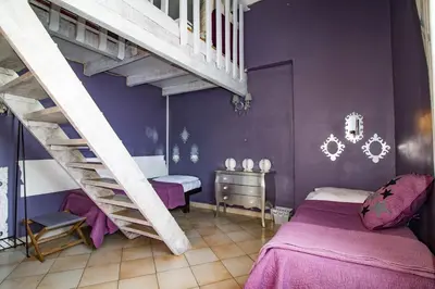 a bedroom with purple walls and a spiral staircase at Mountain Lodge Corse Odyssée in Quenza