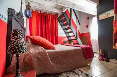 a bedroom with a bed with a red wall at Mountain Lodge Corse Odyssée in Quenza