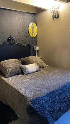 a bedroom with a bed and a clock on the wall at Mountain Lodge Corse Odyssée in Quenza