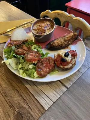 a plate of food with a salad and sausage and bread at Mountain Lodge Corse Odyssée in Quenza