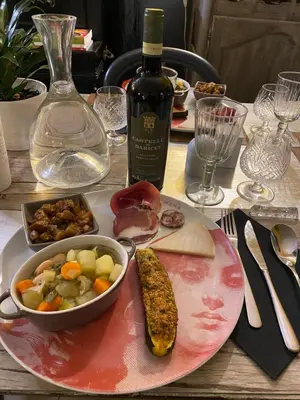 a table with a plate of food and a bottle of wine at Mountain Lodge Corse Odyssée in Quenza