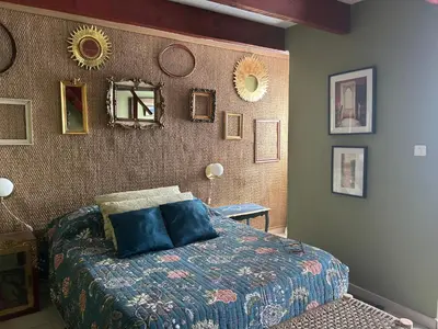 a bedroom with a bed and a wall with mirrors at Mountain Lodge Corse Odyssée in Quenza