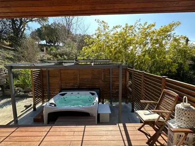 a patio with a hot tub on a deck at Maison de vacances in Aléria