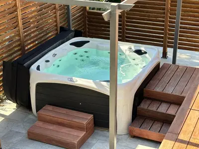 a jacuzzi tub on a deck with stairs at Maison de vacances in Aléria