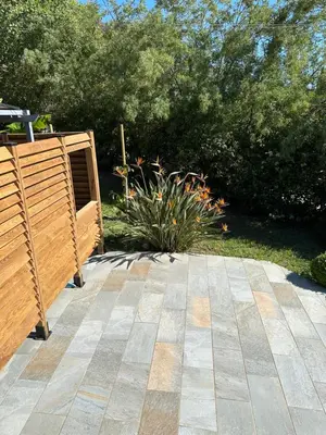 a patio with a wooden fence and a plant at Maison de vacances in Aléria