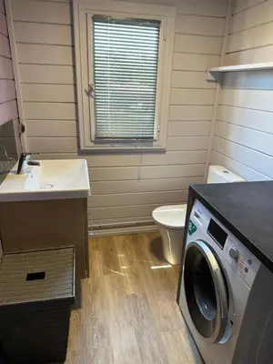 a bathroom with a washing machine and a toilet at Maison de vacances in Aléria