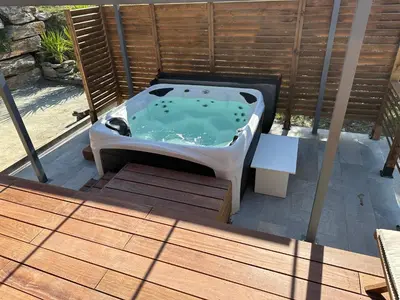 a hot tub sitting on top of a wooden deck at Maison de vacances in Aléria