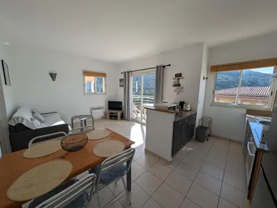 a kitchen and dining room with a table and chairs at Appartement T2 bord de plage in Sartène