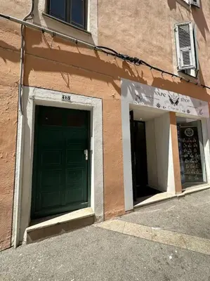 a building with two green doors on the side of it at T2 hyper centre ville in Ajaccio