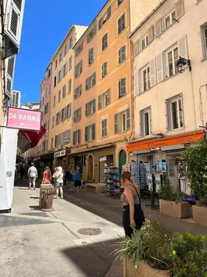a woman standing on a city street with buildings at T2 hyper centre ville in Ajaccio