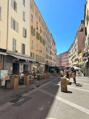 a city street with people sitting at tables and buildings at T2 hyper centre ville in Ajaccio