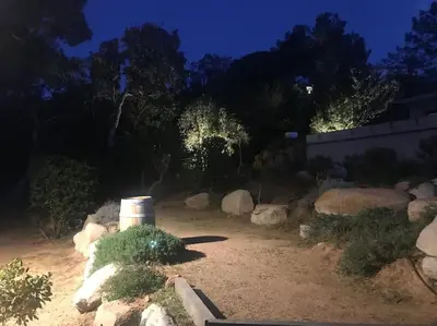 a garden with rocks and trees at night at Villa privée-piscine-vue mer-pinarello-cirindinu in Zonza