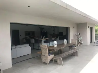 a dining room and living room with a table and chairs at Villa privée-piscine-vue mer-pinarello-cirindinu in Zonza
