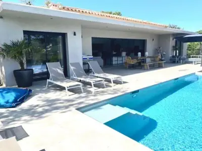 a swimming pool with chairs and a house at Villa privée-piscine-vue mer-pinarello-cirindinu in Zonza