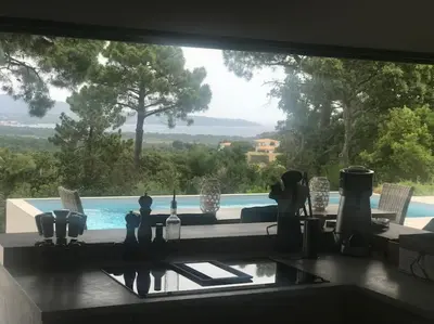 a kitchen window with a view of a swimming pool at Villa privée-piscine-vue mer-pinarello-cirindinu in Zonza