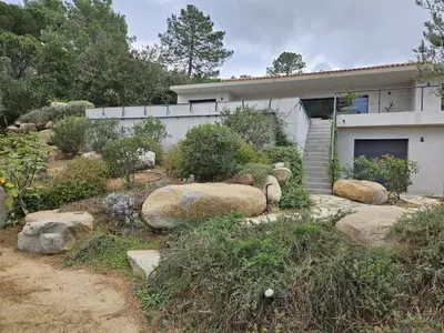 a house with some rocks in front of it at Villa privée-piscine-vue mer-pinarello-cirindinu in Zonza