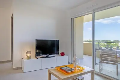 a living room with a flat screen tv and a table at Casa Ornella in Vescovato