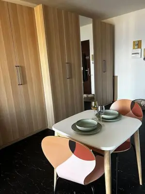 a dining room table with two chairs and a white table with plates at Studio climatisé belle vue mer in Ajaccio