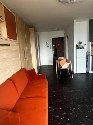 a living room with an orange couch and a table at Studio climatisé belle vue mer in Ajaccio