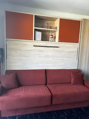 a red couch sitting in a living room at Studio climatisé belle vue mer in Ajaccio