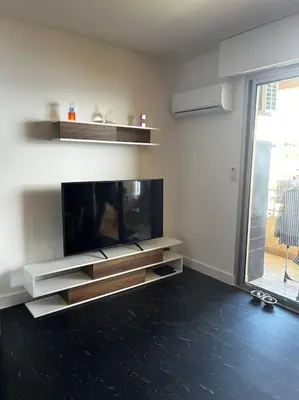 a living room with a flat screen tv on a wall at Studio climatisé belle vue mer in Ajaccio