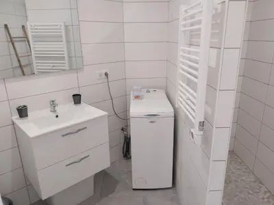 a white bathroom with a sink and a mirror at Magnifique appartement entre mer et montagne in Tiuccia