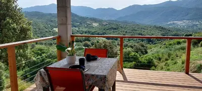a table on a balcony with a view of mountains at Magnifique appartement entre mer et montagne in Tiuccia