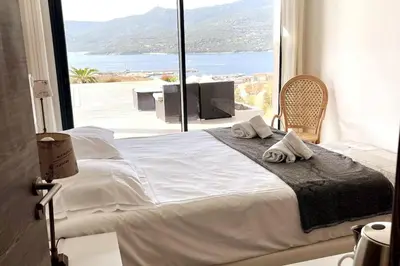 a bed in a room with a large window at Casa di l'Alivi - Villa avec vue exceptionnelle in Propriano