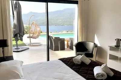 a bedroom with a bed and a view of a pool at Casa di l'Alivi - Villa avec vue exceptionnelle in Propriano